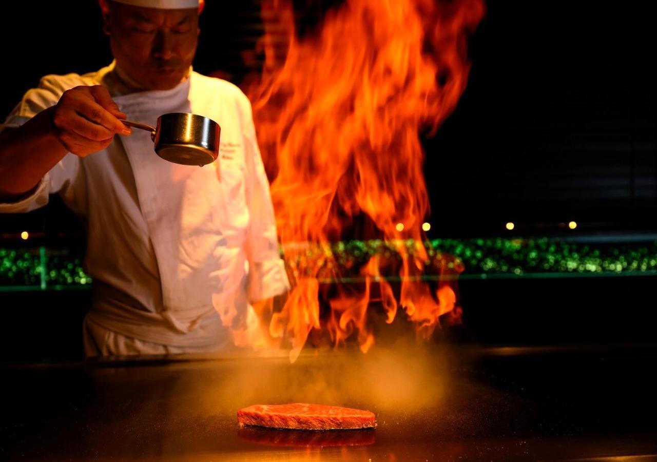 منتجع وسبا فندق مونتيري أوكيناوا أونا المظهر الخارجي الصورة A chef cooking with the technique of flambe